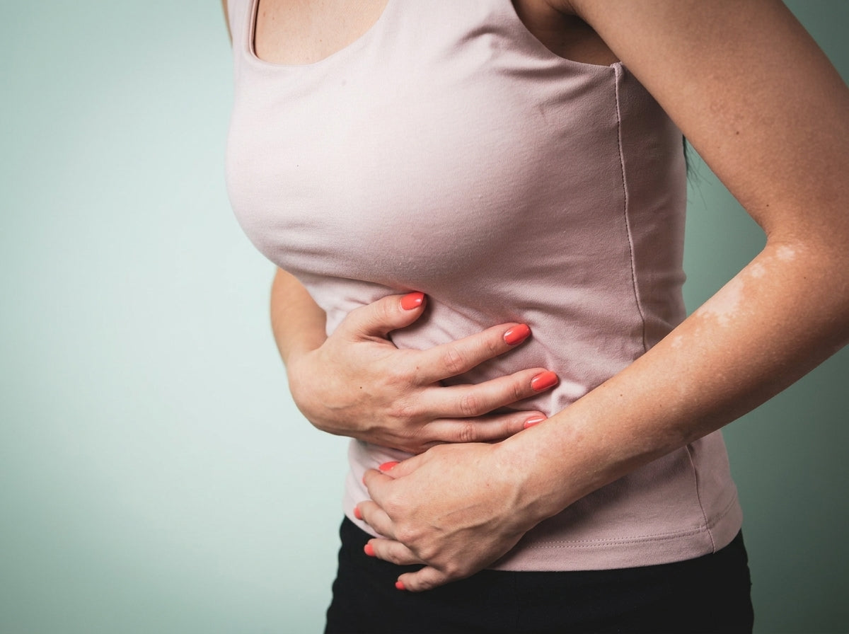 stomach bug concept image - woman holding stomach with both hands